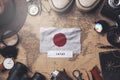 Japan Flag Between Traveler`s Accessories on Old Vintage Map. Overhead Shot Royalty Free Stock Photo