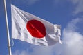 Japan flag waving in the wind against blue sky. Close up image Royalty Free Stock Photo