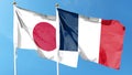 Japan and France flags against cloudy sky. Royalty Free Stock Photo