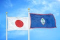 Japan and Guam two flags on flagpoles and blue cloudy sky