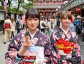 Japan. Tokyo. A japanese girl tasting sweets in the streets of Asakusa with her western friend Royalty Free Stock Photo