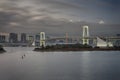 Japan Travel Destinations. View of Rainbow Bridge in Odaiba Island in Tokyo At Twilight with Line of Skyscrapers Royalty Free Stock Photo