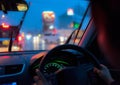 Inside a car driven by a woman under the rain by night.