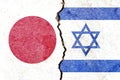 Japan vs Israel flags on cracked wall, political conflict concept Royalty Free Stock Photo