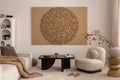 Japandi living room interior with mock up poster frame, modern black coffee table, rounded shapes armchair, beige sofa, vase with