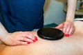 Japanese back massage with warm black stones in the massage parlor Royalty Free Stock Photo