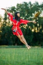 Japanese ballerina jumps on lawn and trees background Royalty Free Stock Photo