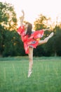 Japanese ballerina in red kimono stands in swallow pose Royalty Free Stock Photo