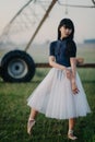 Ballerina dances in field on background of agricultural sprayer Royalty Free Stock Photo