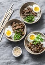 Japanese beef, rice and boiled egg bowl on grey background, top view. Asian food concept Royalty Free Stock Photo