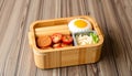 Japanese bento box with a variety of foods including egg, sausages, and vegetables for lunch Generative AI