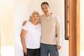 Japanese-born mother and son stand smiling embraced looking at camera