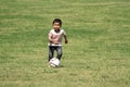 Japanese boy kicking a soccer ball Royalty Free Stock Photo