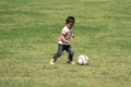 Japanese boy kicking a soccer ball Royalty Free Stock Photo