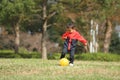 Japanese boy kicking a yellow ball Royalty Free Stock Photo