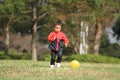 Japanese boy kicking a yellow ball Royalty Free Stock Photo