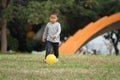 Japanese boy kicking a yellow ball Royalty Free Stock Photo