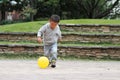 Japanese boy kicking a yellow ball Royalty Free Stock Photo