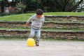 Japanese boy kicking a yellow ball Royalty Free Stock Photo