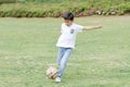 Japanese boy playing with soccer ball Royalty Free Stock Photo