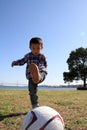 Japanese boy playing with soccer ball Royalty Free Stock Photo