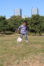 Japanese boy playing with soccer ball Royalty Free Stock Photo