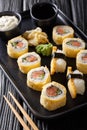 Japanese breakfast set tamagoyaki sushi roll with rice, cheese, salmon and avocado closeup on a plate. vertical