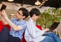 Japanese brother using tablet device and laptop computer in the living room