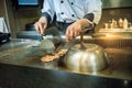 Japanese Chef cooking chiken steak on hot pan in front of custom