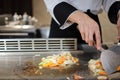 Japanese chef deliberately preparing and cooking traditional beef teppanyaki
