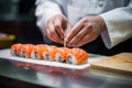 A Japanese chef prepares salmon sushi rolls