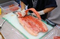 Japanese chef in restaurant slicing raw fish for salmon sushi. Chef preparing a fresh salmon on a cutting board Royalty Free Stock Photo