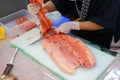 Japanese chef in restaurant slicing raw fish for salmon sushi. Chef preparing a fresh salmon on a cutting board Royalty Free Stock Photo