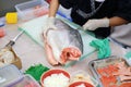 Japanese chef slicing raw fish for salmon sushi. Chef preparing a fresh salmon on a cutting board