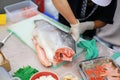 Japanese chef slicing raw fish for salmon sushi. Chef preparing a fresh salmon on a cutting board