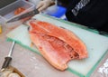 Japanese chef slicing raw fish for salmon sushi. Chef preparing a fresh salmon on a cutting board