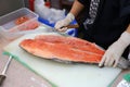 Japanese chef slicing raw fish for salmon sushi. Chef preparing a fresh salmon on a cutting board Royalty Free Stock Photo