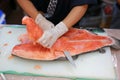 Japanese chef slicing raw fish for salmon sushi. Chef preparing a fresh salmon on a cutting board Royalty Free Stock Photo