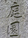 Japanese / Chinese letters signifying `Garden` engraved on stone wall. Royalty Free Stock Photo