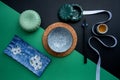 Japanese or Chinese table setting with traditional table mat and dinnerware with green and black background. Royalty Free Stock Photo