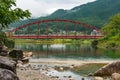 Japanese countryside landscape with bright red bridge over Kiso