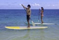 Japanese couple on paddle boards Royalty Free Stock Photo