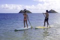 Japanese couple on paddle boards Royalty Free Stock Photo