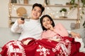 Japanese Couple Watching TV On Christmas Eve Sitting At Home Royalty Free Stock Photo