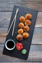 Japanese cuisine. Baked sushi with crab meat and cheese on a stone slab in a dark wood background. Top view Royalty Free Stock Photo