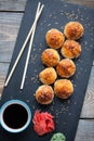 Japanese cuisine. Baked sushi with crab meat and cheese on a stone slab in a dark wood background. Top view Royalty Free Stock Photo