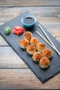 Japanese cuisine. Baked sushi with crab meat and cheese on a stone slab in a dark wood background. Top view Royalty Free Stock Photo