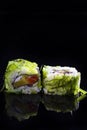 Japanese Cuisine. Pair of Traditional Sushi Rolls With Green Sea Algae Together on Black Reflective Surface Royalty Free Stock Photo