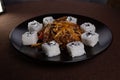 Japanese cuisine, rice rolls with sesame seeds and soy sauce on a black plate Royalty Free Stock Photo