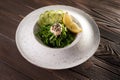 Japanese Cuisine, Seaweed salad Goma Wakame with nut sauce in white plate on table background.